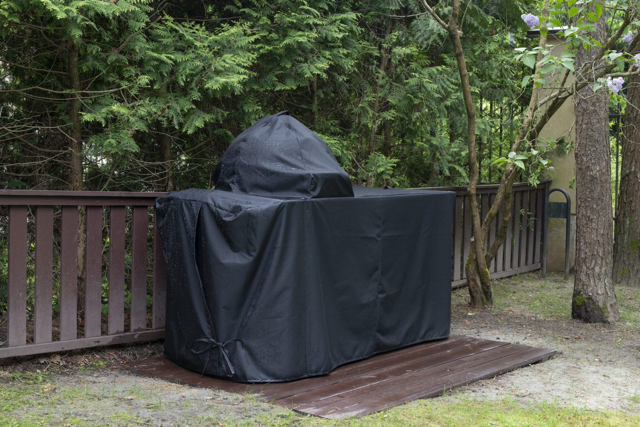 Barbecue grill Cover protecting kamado style ceramic grill from rain.